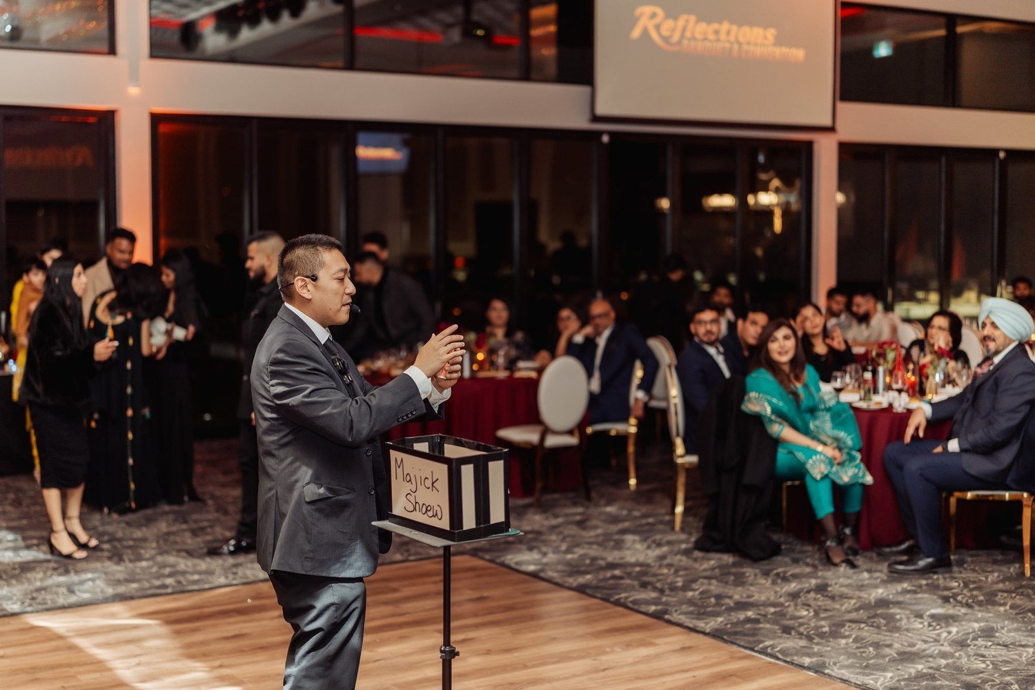 John Ha performing for a full room of guests during an upscale event