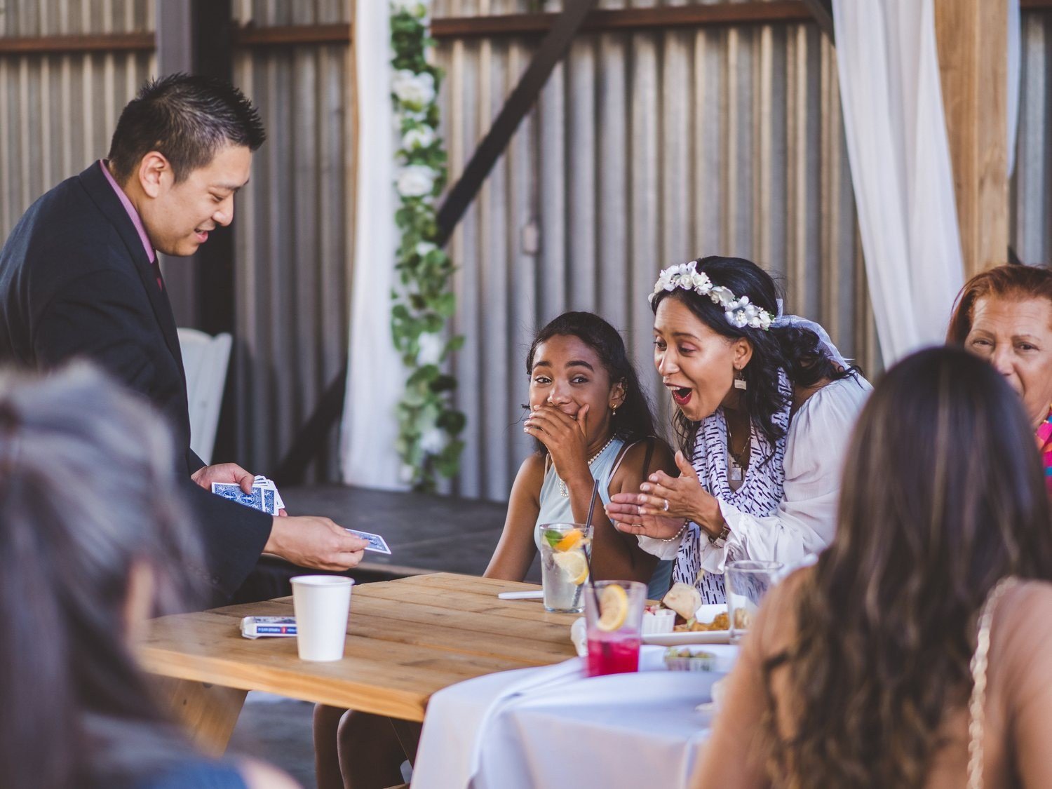 Wedding guests reacting warmly as John Ha performs close-up magic