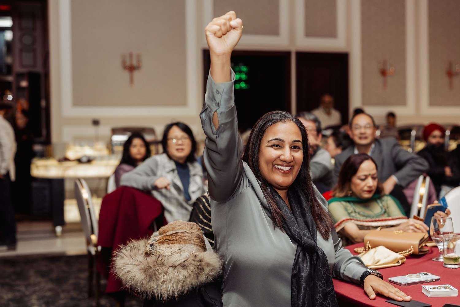 A guest cheering and smiling during John Ha Magic at a Vancouver event